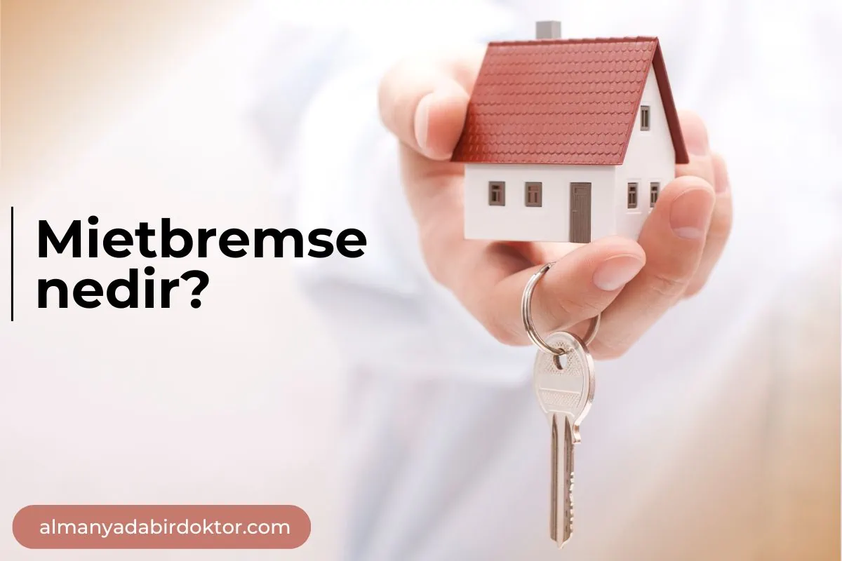Üzerinde Mietpreisbremse nedir yazan bir ev maketini tutan kişi.
